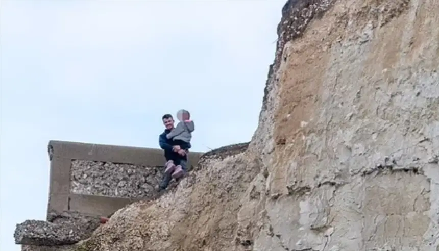 رجل يخاطر بحياة طفلته من أجل صورة على حافة جرف خطير