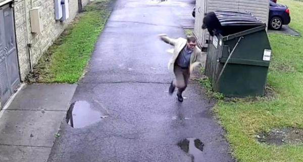 دب ضخم مختبئ في حاوية قمامة يفاجئ مدير مدرسة(فيديو)