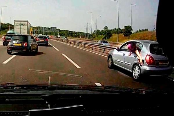 بالفيديو: لماذا تدلى هذا الرجل من نافذة سيارته المسرعة؟