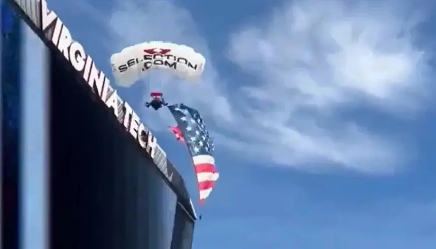 مظلي ينحرف عن مساره ويعلق بشاشة عملاقة في ملعب أمريكي وسط ذهول الجماهير