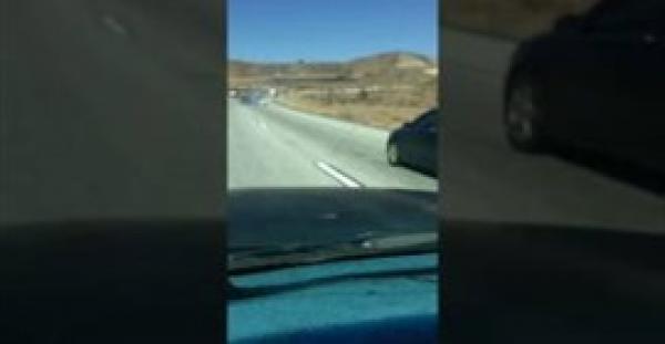 بالفيديو.. لحظة جر سائق شاحنة ضخمة سيارة اصطدم بها على طريق سريع.