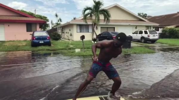 بالفيديو: أمريكيان يركبان أمواج الفيضانات في فلوريدا