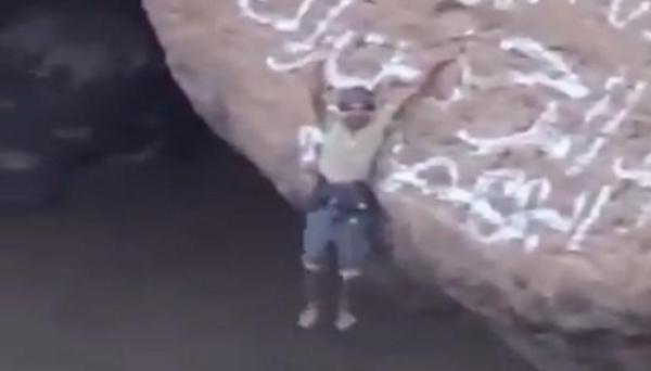 يتدلى من حافة خطيرة وحادة لفوهة بركان بيد واحدة(فيديو)