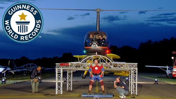 رجل يحمل طائرة حوامة ضخمة على كتفيه