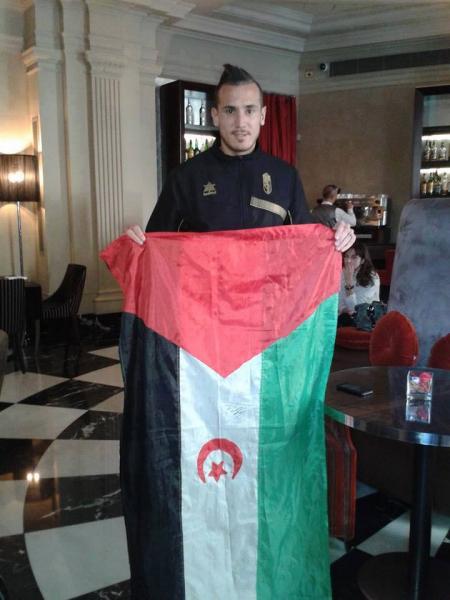 لاعب كرة القدم الجزائري حسن  يبدا يسقط في "فخ" بحمله لعلم "البوليساريو" ظنا منه أنه علم دولة فلسطين