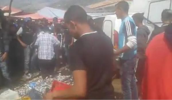 مواطنون  يقومون بإتلاف صناديق من الاسماك و رميها أمام مرأى الناس