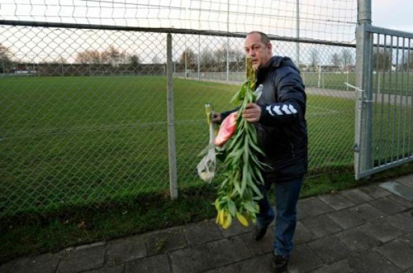 رجل يحمل زهورا في الملعب الذي شهد مقتل الحكم الهولندي (أ ف ب)