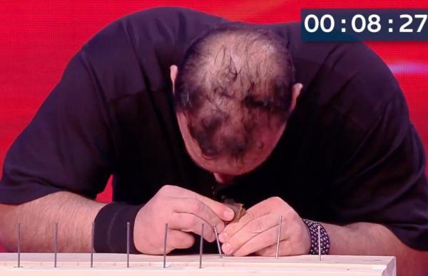 بالفيديو: رجل يُثبّت 38 مسماراً باستخدام رأسه