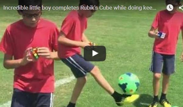 بالفيديو: صبي يحل لعبة المكعب ويلعب الكرة في آن معاً