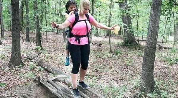 معلمة تحمل طالبة على ظهرها في رحلة مدرسية لمدة يومين