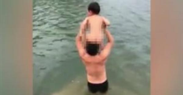 بالفيديو.. لقطات صادمة لأب يرمي ابنه في بحيرة ليعلمه السباحة