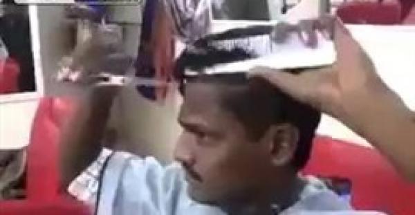 بالفيديو.. حلاق يقص شعره بنفسه في دقيقتين