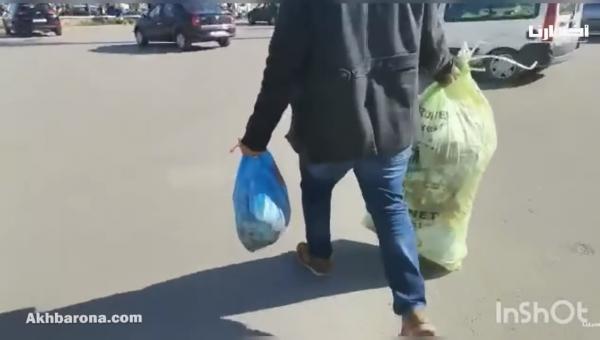 مواطن يرمي الأزبال أمام مدخل جماعة تطوان احتجاجا على تأخر صرف أجرة عمال النظافة