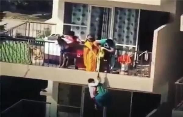 تدلي ابنها من الطابق التاسع ليجلب قطعة ملابس سقطت من شرفتها(فيديو)