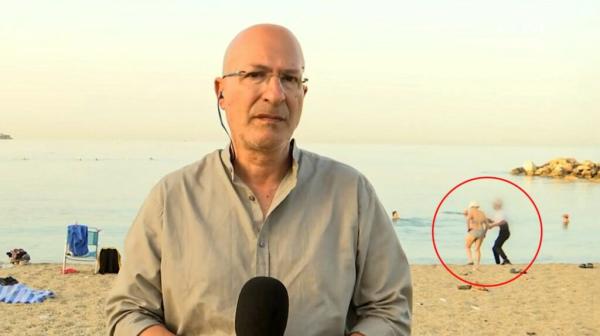 لص غير محظوظ  ظهر في بث مباشر وهو يسرق امرأة على الشاطئ(فيديو)