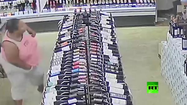 امرأة تسرق عشرات من زجاجات الكحول الغالي من محل تجاري