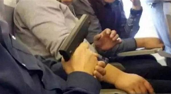 مسافرون يلتقطون صوراً مع مسدس على متن طائرة