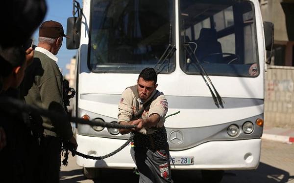 فلسطيني يجر حافلة تزن 12 طناً