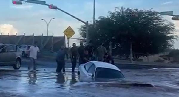 لحظة ابتلاع حفرة مليئة بالماء لسيارة داخلها امرأة (فيديو)