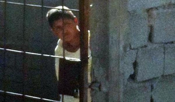   الطفلة المحتجزة وهي خلف الباب الحديدي  -  مصدر الصورة : منارة