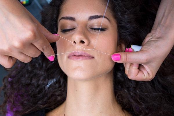 طرق لتقليل الشعور بالألم عند إزالة شعر الوجه الزائد بالخيط.