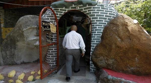 بالصور: رجل يبني منزلاً تحت الأرض بمعول ومجرفة