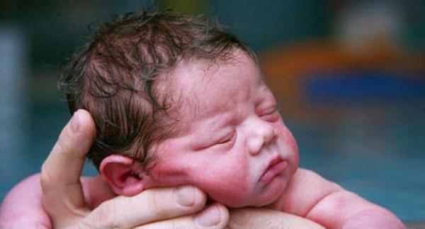 بالصور .. أصغر طفل في العالم يخوض تجربة السباحة