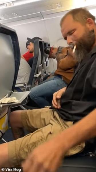 رجل يشعل سيجارة على متن طائرة