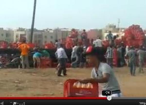 نهب شاحنة مشروبات غازية بعد انقلابها 