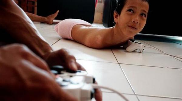 بالفيديو: طفل بلا أطراف يكتب فروضه المدرسية بفمه