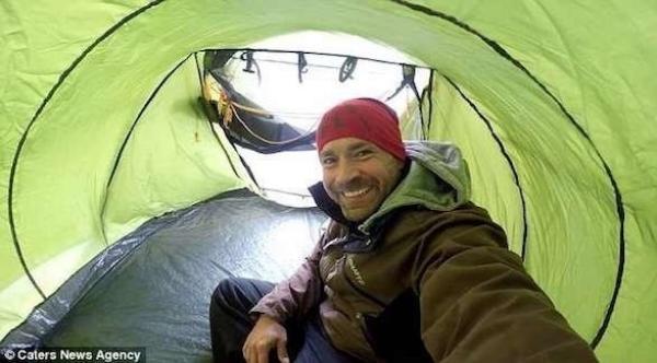 مغامر ينصب خيمة على فوهة مدخنة شاهقة الارتفاع