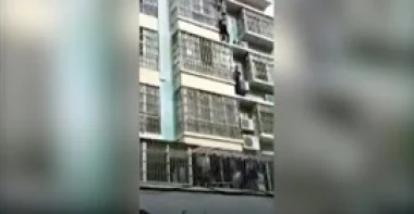 رجلان يتسلقان مبنى لإنقاذ طفل يتدلى من مبنى في مشهد بطولي (فيديو)