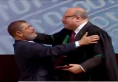 فيديو.. طبيب مرسي الخاص يحاول تقبيل رأسه باحتفالية عيد العلم.. والرئيس يرفض