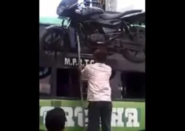 بالفيديو: رجل يصعد حافلة حاملاً دراجة نارية فوق رأسه