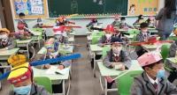 "قبعات التباعد" على رؤوس التلاميذ الصينيين بعد فتح المدارس