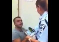 أحد المعتقلين الفلسطينيين في نقطة شرطة اسرائيلية، والمحققة تحاول أخذ إسمه بالكامل، انظر ماذا فعل