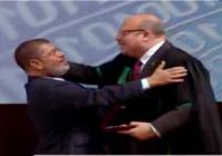 فيديو.. طبيب مرسي الخاص يحاول تقبيل رأسه باحتفالية عيد العلم.. والرئيس يرفض