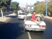 طفل يغامر بحياته بركوبه فوق طاكسي