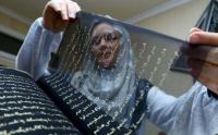 لأول في تاريخ الإسلام : فنانة " أذربيجانية " تنجز مصحفا مكتوبا بلون ذهبي على قماش من حرير ( الصور )