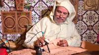 مغربي "مُقعد" يخط بمكواة مصحفا على جلد الماعز